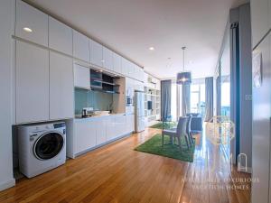 a kitchen with white cabinets and a washer and dryer at The Platinum Kuala Lumpur by LUMA in Kuala Lumpur