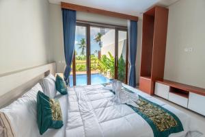 a bedroom with a large bed and a large window at Sawitri Ubud Villas in Blahbatu +83 photos