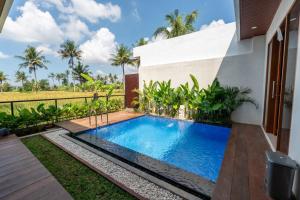 a swimming pool in the backyard of a house at Sawitri Ubud Villas in Blahbatu
