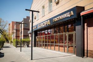 a store with a sign on the side of a building at EUROPA Hotel in Semey