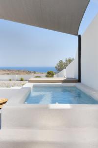 an outdoor swimming pool with a large glass window at Acro Caldo Suites in Akrotiri
