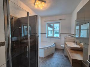 a bathroom with a tub and a sink and a shower at Auszeitplatzl in Unken