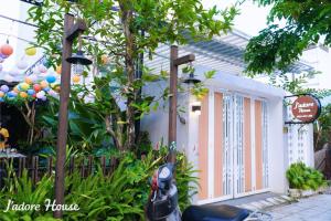 a house with a motorcycle parked in front of a door at Jadore House in Danang
