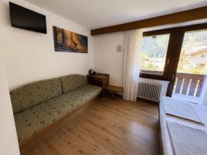 a living room with a couch and a television at Chalet La Felce in Carisolo