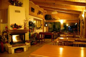 a restaurant with a fireplace and tables and chairs at Ośrodek Wczasowy Sokół in Rabka-Zdrój