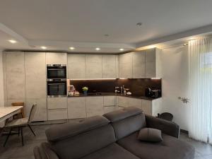 a living room with a couch and a kitchen at Terraced apartment in Kayl