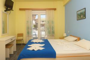 a bedroom with a bed with towels on it at Hotel Dias Apartment in Makrygialos