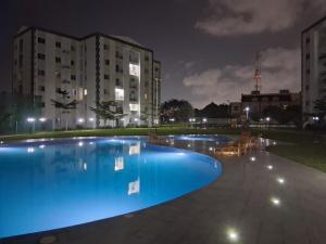 a large swimming pool with blue lighting in front of a building at Ocean View Apartments in Sakumona