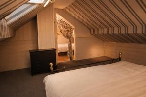 a attic bedroom with a bed and a mirror at Kamer midden in de Ardennen in Amblève