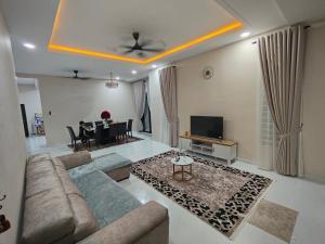 a living room with a couch and a dining room at D'Jawa Homestay in Baling
