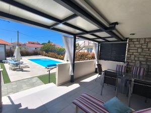 a patio with a view of a swimming pool at Royal place in Nin