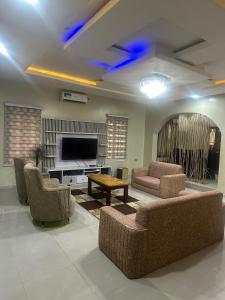 ein Wohnzimmer mit Sofas und einem Flachbildfernseher in der Unterkunft The Bubbles Hotel in Akobo