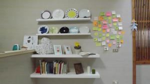 een kamer met witte planken met borden en boeken bij Domus Tua in Pietrelcina