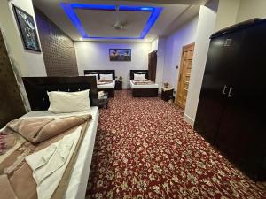 a bedroom with two beds and a red carpet at Taj luxury hotel Quetta in Quetta +13 photos