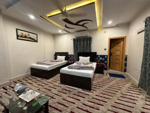 two beds in a room with a rug at Taj luxury hotel Quetta in Quetta