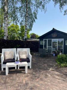 two chairs and a coffee table on a patio at De Veldeling in Hollandscheveld