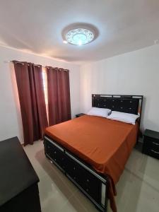 a bedroom with a large bed with an orange blanket at Apartment Ñ4 in La Grúa
