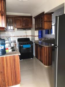 a kitchen with wooden cabinets and a black refrigerator at Apartment Ñ4 in La Grúa +9 photos