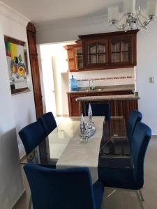 a dining room with a table and blue chairs at Apartment Ñ4 in La Grúa