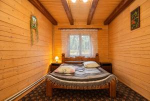 a bedroom with a bed in a log cabin at Котедж Славний гуцул & СПА чани джакузі in Yablunytsya +21 photos