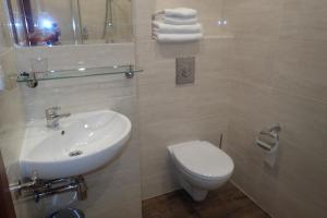 łazienka z białą umywalką i toaletą w obiekcie Gościniec Pan Tadeusz II w mieście Giżycko