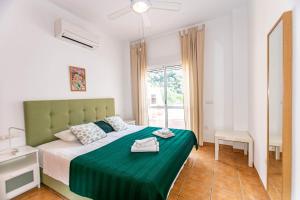 a bedroom with a green bed and a window at Casa Verdejo in Cómpeta +8 photos