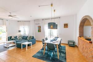 a living room with a table and a blue couch at Casa Verdejo in Cómpeta