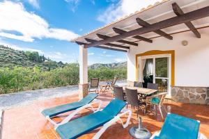 a patio with chairs and a table with a view at Casa Verdejo in Cómpeta