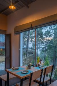 a dining room with a table and a large window at BluSalzz Escapade Resort Lansdowne in Lansdowne
