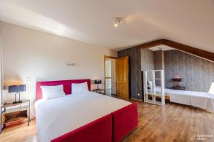 a bedroom with a large bed with a red headboard at Villa Pal'Ange Hotelservice Playstation 5 Billiard in Durbuy +44 photos