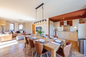 a kitchen and living room with a wooden table and chairs at Villa Pal'Ange Hotelservice Playstation 5 Billiard in Durbuy