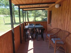 a wooden porch with a table and chairs on it at Zielona Polana in Debrznik +17 photos