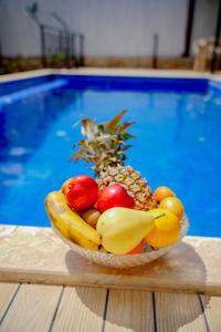 a bowl of fruit on a table next to a pool at Comfy Villa Ipek with Pool in Kaş