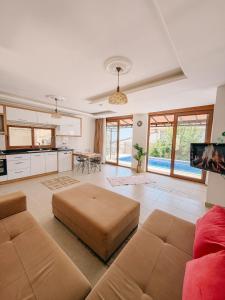 a large living room with a couch and a kitchen at Comfy Villa Ipek with Pool in Kaş +9 photos