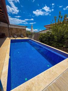 a swimming pool with blue water in a backyard at Comfy Villa Ipek with Pool in Kaş