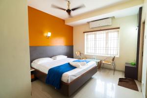 a bedroom with a large bed and a window at PLA Residency Tanjore in Thanjāvūr