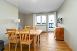 a dining room with a table and chairs and a television at Gasthaus Schwielochsee in Friedland