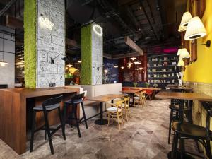 a restaurant with tables and chairs and green walls at Ibis Poznan Centrum in Poznań