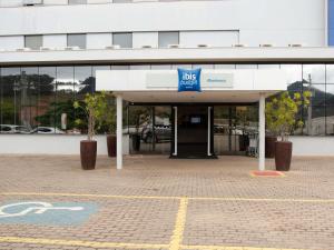 an office building with a bus sign in front of it at ibis budget Manhuaçu in Manhuaçu