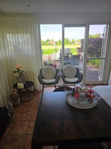 a living room with two chairs and a table at De Veldeling in Hollandscheveld
