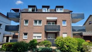 an apartment building with balconies and bushes at Rudolph Apartments Kleve in Kleve