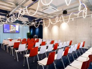 a conference room with red and white chairs at ibis budget Gent Centrum Dampoort in Ghent