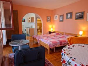 a bedroom with two beds and a table in it at Apartments Grace in Rovinj