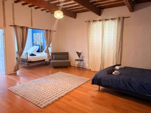 a bedroom with a bed and a couch and a chair at Le jardin de Grignan in Réauville +59 photos