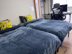 two beds sitting next to each other in a room at Cafe Sharehouse Kokoro Nest Kyoto in Kyoto