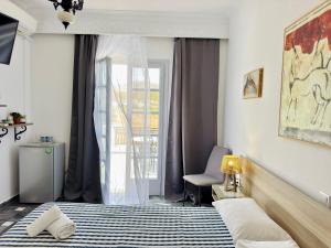 a bedroom with a bed and a window at Tritonas Rooms in Kamari