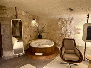 a bathroom with a tub and a chair and a mirror at Miras Hotel in Göreme +40 photos