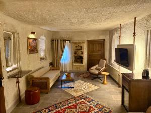 a living room with a couch and a tv at Miras Hotel in Göreme