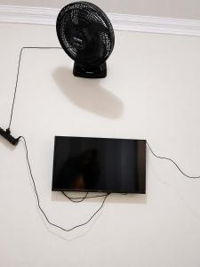 a black fan sitting on top of a tv at Jams Hostel - Pousada em Catalão in Catalão