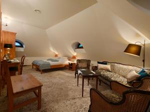 a living room with a bed and a couch at Dworek Kazimierski in Kazimierz Dolny